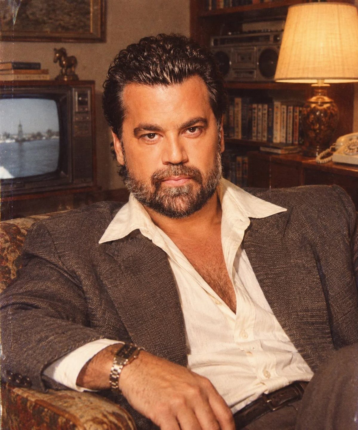 Man wearing an oversized grey suit jacket with shoulder pads and white shirt.