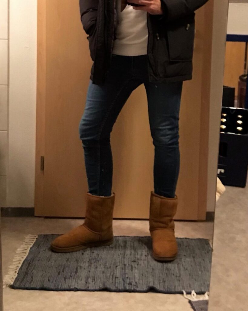 Tan Ugg boots paired with blue skinny jeans and a black jacket.