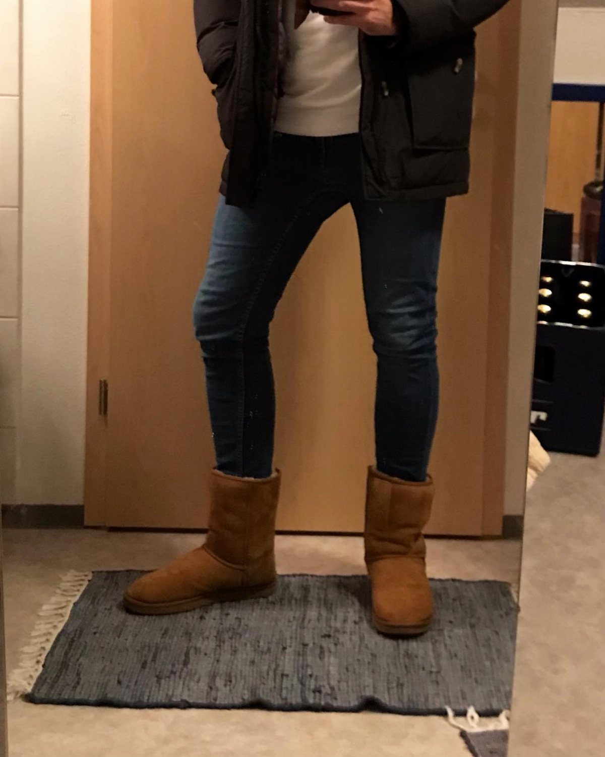 Tan Ugg boots paired with blue skinny jeans and a black jacket.