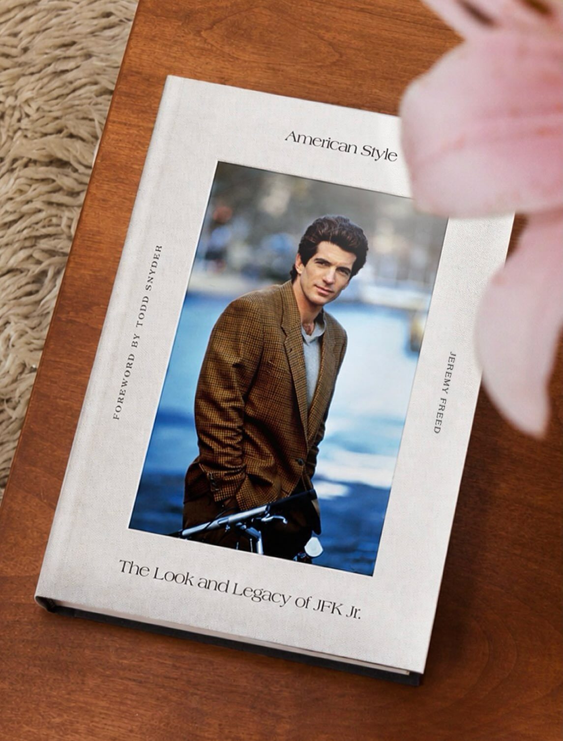 Hardcover book titled American Style featuring JFK Jr. in a brown blazer on wood.