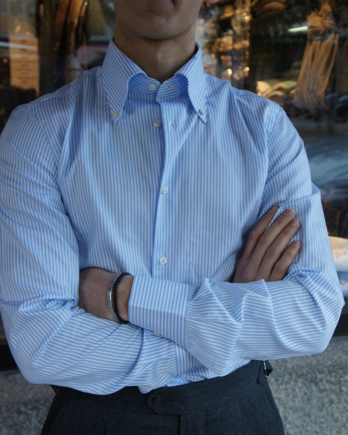 Man wearing a blue striped dress shirt with a button-down collar and grey trousers